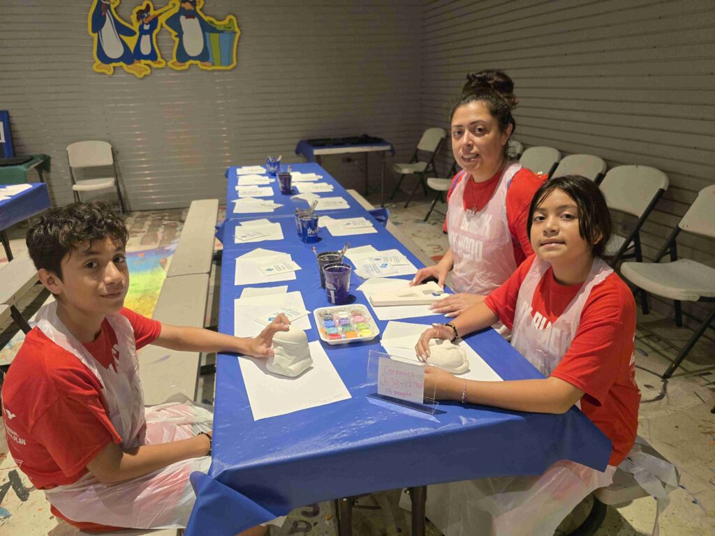 Participantes pintando cerámica en la actividad Pingüino Pintado